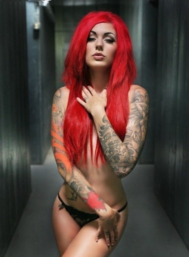 Татуированная негритянка с рыжими волосами раздевается на кровати